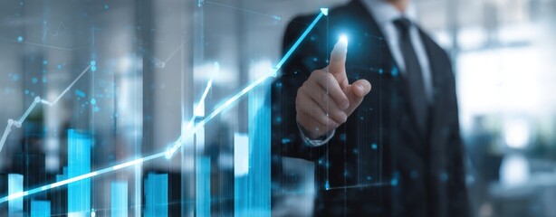 The businessman pointing at rising digital financial chart in modern office