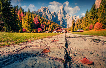 Colorful autumn view of hottel on Pradidali valley, Province of Trento, Italy, Europe. Wonderful morning scene of Dolomite Alps with old country road. Beauty of countryside concept background.