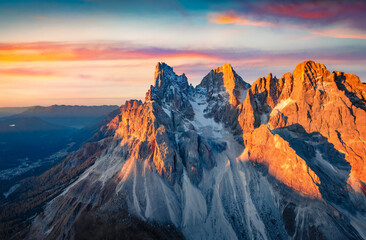 Spectacular autumn sunrise in Dolomite Alps. Great morning view from flying drone of Cimon della Pala peak, Italy, Europe. Beauty of nature concept background.