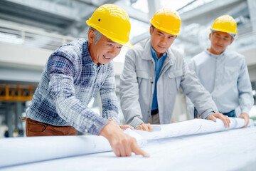 Professional architects and engineers working as a team on a construction project plan in the office