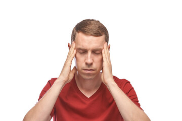 Fototapeta premium Young caucasian male experiencing stress with eyes closed and hands on temples in red shirt.