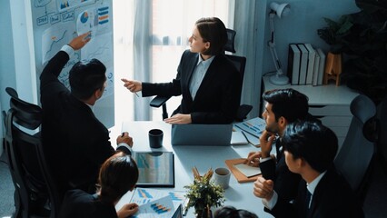 Top view of smart executive manager holding stock market investment chart while planning marketing strategy with diverse group. Smart business team brainstorming and working together. Directorate.
