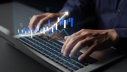 A close-up view of hands working on a laptop keyboard, with visually represented charts and graphs illustrating financial trends and growth in a modern workspace. Copula