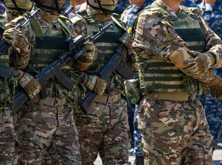 men in camouflage uniforms holding assault rifles outdoors