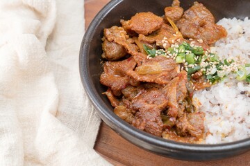 Jeyukdeopbap, Korean Food Spicy Stir-fried Pork with Rice in Black Bowl 