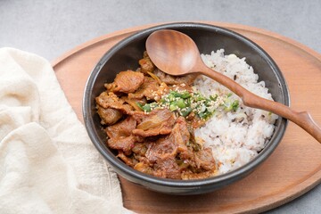 Jeyukdeopbap, Korean Food Spicy Stir-fried Pork with Rice in Black Bowl 
