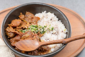 Jeyukdeopbap, Korean Food Spicy Stir-fried Pork with Rice in Black Bowl 