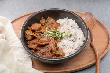 Jeyukdeopbap, Korean Food Spicy Stir-fried Pork with Rice in Black Bowl 