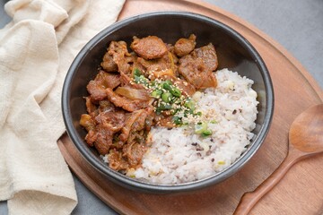 Jeyukdeopbap, Korean Food Spicy Stir-fried Pork with Rice in Black Bowl 