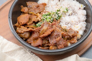 Jeyukdeopbap, Korean Food Spicy Stir-fried Pork with Rice in Black Bowl 