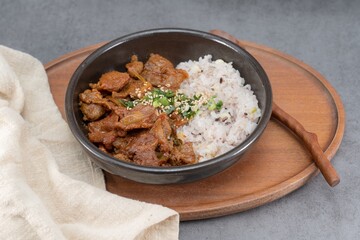 Jeyukdeopbap, Korean Food Spicy Stir-fried Pork with Rice in Black Bowl 