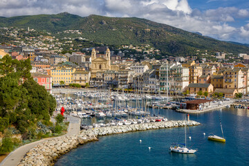 view of Bastia marina and the old town with Saint-Jean-Baptiste church and calm blue sea bathed in warm morning sunlight
