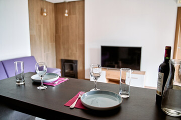 Elegant Dining Setup in a Modern Living Space Featuring Glassware, Plate Settings, and Contemporary Decor for a Cozy Meal Experience