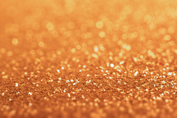 A shimmering golden glitter background with soft bokeh lights creating a luxurious and festive abstract texture.