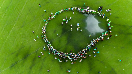 Port Harcourt, Nigeria - 01 October 2025: Aerial view of a gathering around a water body, a vibrant display of green and white against the verdant field.