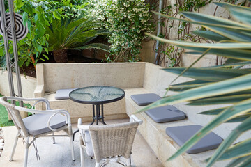 Tranquil Outdoor Seating Area Surrounded by Lush Greenery and Elegant Decor, Perfect for Relaxation and Enjoying Nature's Beauty