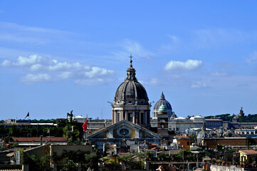Fototapeta premium Rome, Italy areal view of rooftops viewed from the top of Spanish Steps. church cupolas and clay residential roofs. blue sky background. white clouds. travel and tourism concept. St. Peter's Basilica