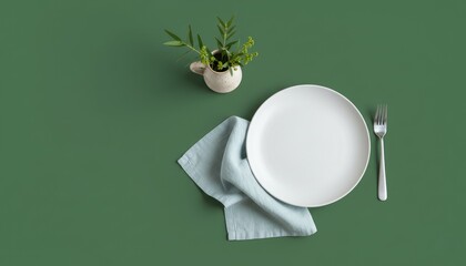 Minimal table setting with white plate, fork and light blue napkin on green background, simple dining concept with plant decor