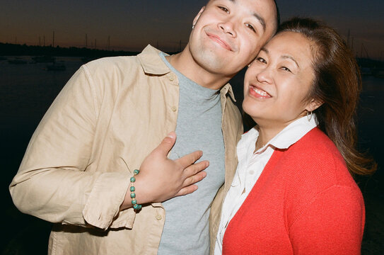Mom and son looking at the camera outside.