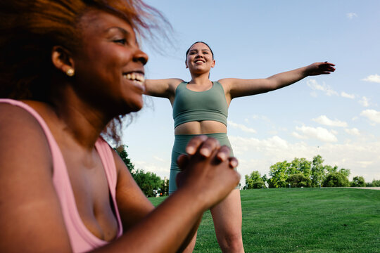 Curvy female friends have good time during an outdoor workout session