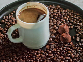A coffee cup with two chocolate truffles - perfect coffee and dessert pairing