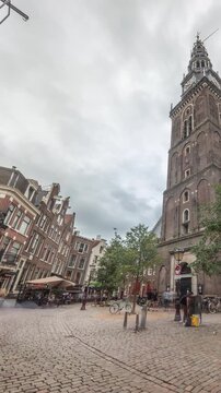Hyperlapse of Amsterdam's Old Church (Oude Kerk), the city's oldest parish church, surrounded by historical houses in De Wallen district on Oudekerksplein timelapse. Iconic landmark in the Netherlands