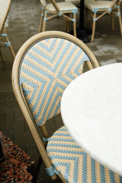 Woven bistro chair beside white marble cafe table