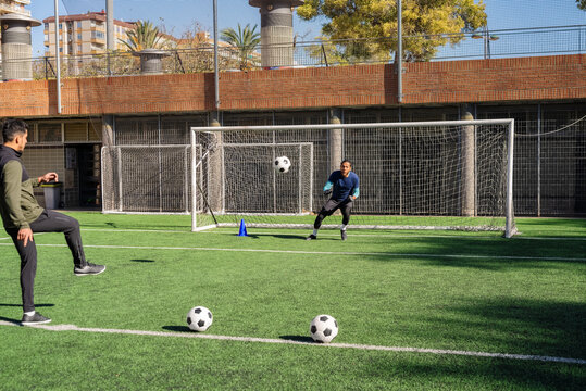 Players practicing shots and goalkeeping