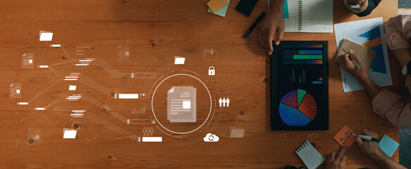 A modern collaborative workspace showcasing team members analyzing data reports with digital visuals, emphasizing the fusion of technology and strategy in business tasks. Trope