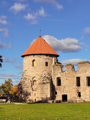 Obraz premium The beautiful medieval castle ruins and restored tower in the historic town of Cēsis, Latvia, on a sunny autumn day.