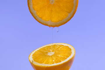orange juice dripping between the slices on a vibrant blue 