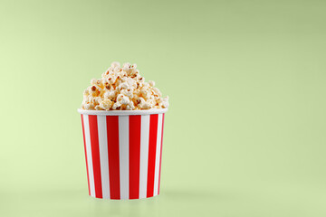 Classic red striped popcorn cardboard cup on Green background