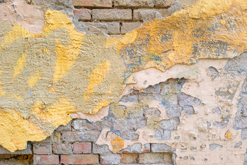 Old Brick Wall with Peeling Plaster and Paint Layers