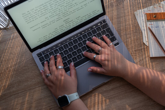 Writer hands typing on laptop keyboard