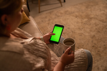 Woman using smartphone with green screen