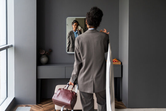  Businesswoman Checking Appearance in Hotel Mirror