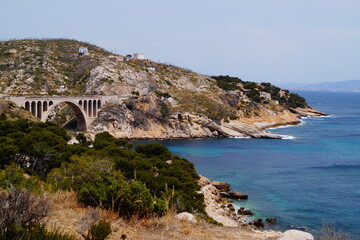Top view of the Mediterranean sea, bridge and mountain rocks with trees and houses near Marseille, Provence, France.