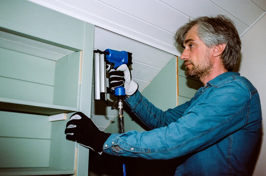 Man using pneumatic nail gun for home renovation