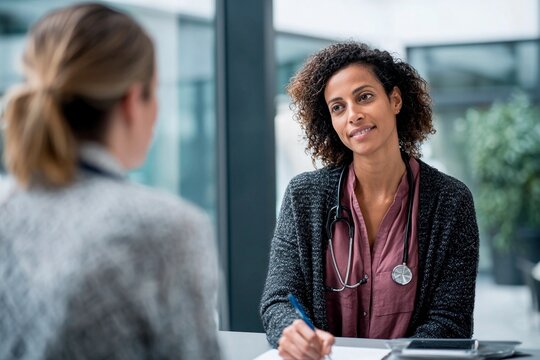 A healthcare provider meets with a patient in a modern office setting, discussing concerns while taking notes. The atmosphere is calm and professional, focusing on patient care