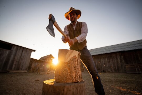 Rustic man chopping wood, golden hour sunflare