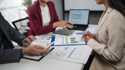 Business team collaborating on financial reports and data analysis, finding solutions for business planning and strategy in office