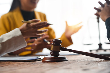 Lawyers and clients meeting to discuss legal consultation, justice system, and regulations. Gavel and scales of justice on desk