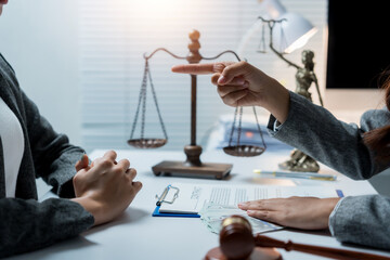 Lawyer pointing a finger at a client during a legal consultation, discussing contract terms and justice in a law office