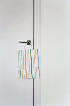 Colorful striped bag hanging on a white door
