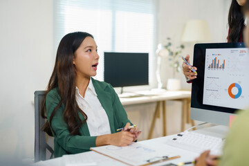 Business executive presenting data analysis charts on a computer screen, discussing strategy and financial planning with a colleague