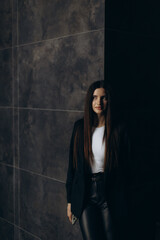 Fototapeta premium Businesswoman Posing Confidently in a Dark Modern Interior Setting