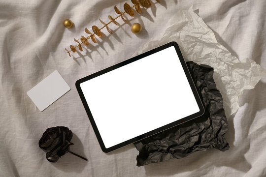 A minimalist flatlay featuring a tablet and a blank card