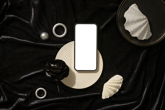 A smartphone mockup with elegant decor on a black fabric