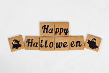 Halloween. Holiday cookies with black marmalade filling in the shape of Happy Halloween and ghosts. White background