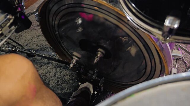 Close-up of a drummer's foot pressing the bass drum pedal with two mallets. View from above. Fast drumming is typical for metal or hardcore bands